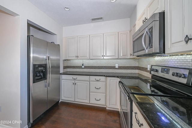 kitchen featuring decorative backsplash, visible vents, stainless steel appliances, and dark wood-style flooring