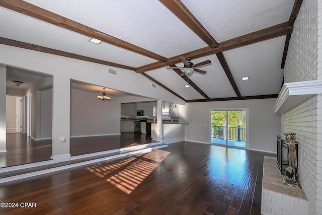 unfurnished living room featuring lofted ceiling with beams, ceiling fan with notable chandelier, a fireplace, visible vents, and wood-type flooring