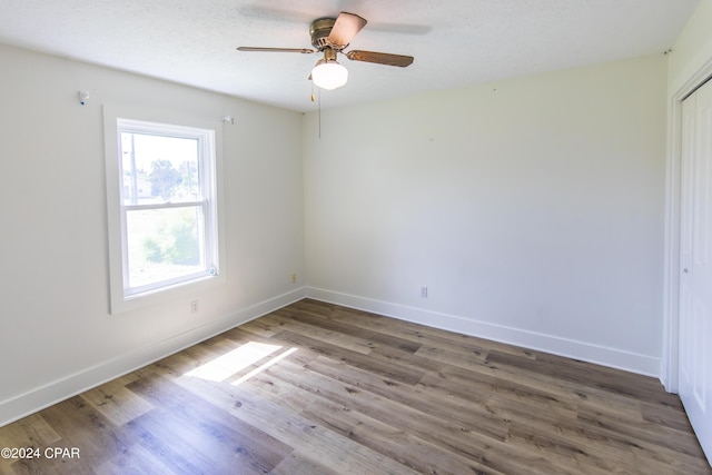 empty room with ceiling fan, hardwood / wood-style floors, and a textured ceiling