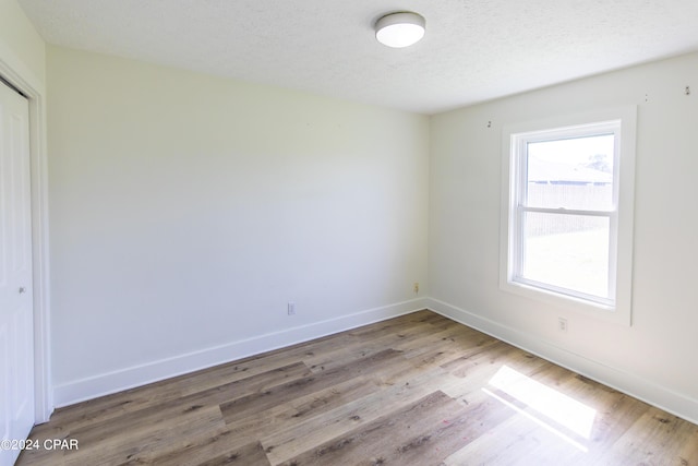 unfurnished room featuring a textured ceiling and hardwood / wood-style flooring