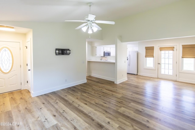 entrance foyer with ceiling fan, lofted ceiling, and light hardwood / wood-style flooring