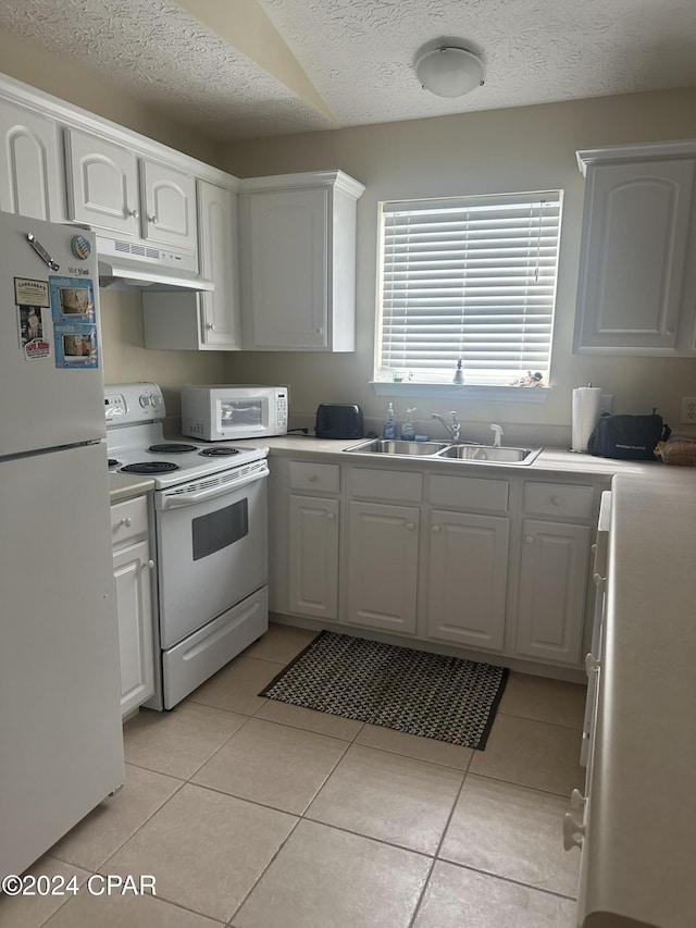 kitchen featuring white appliances, white cabinetry, and sink