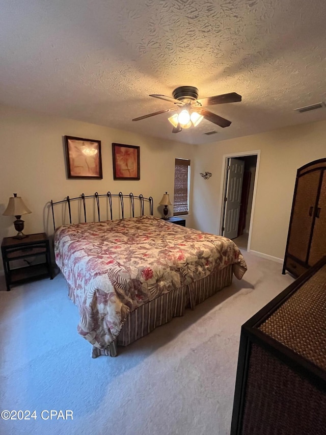 bedroom with carpet flooring, ceiling fan, and a textured ceiling