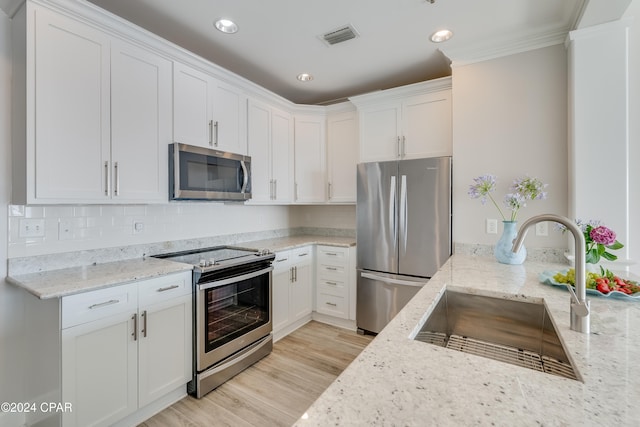 kitchen featuring light stone counters, stainless steel appliances, sink, and white cabinets