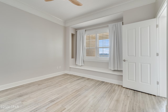 empty room with ornamental molding, light wood-type flooring, and ceiling fan