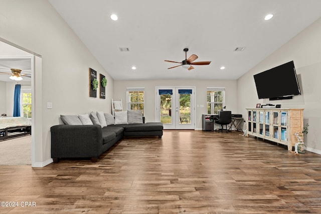 living room featuring lofted ceiling, hardwood / wood-style flooring, and ceiling fan