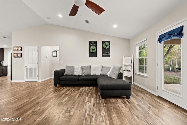 living room with light hardwood / wood-style flooring, ceiling fan, and vaulted ceiling