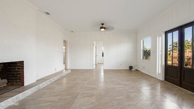 interior space featuring a brick fireplace, ceiling fan, and crown molding