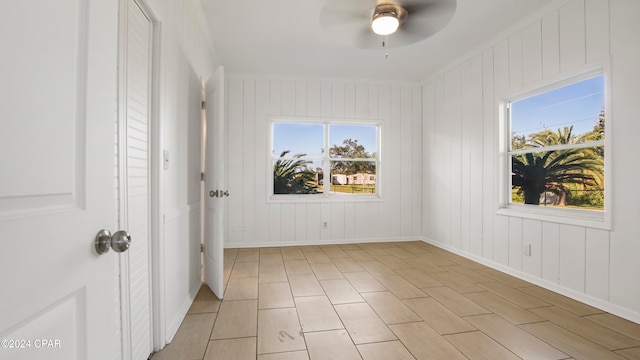 empty room with ceiling fan, plenty of natural light, and ornamental molding