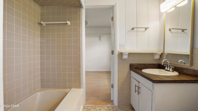 bathroom featuring tile patterned floors, vanity, and tiled shower / bath