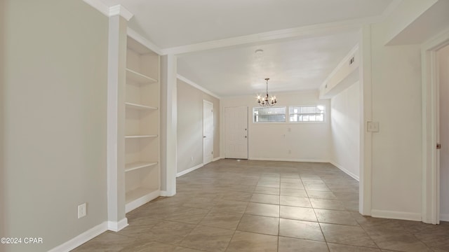 spare room featuring a chandelier, built in shelves, light tile patterned floors, and crown molding