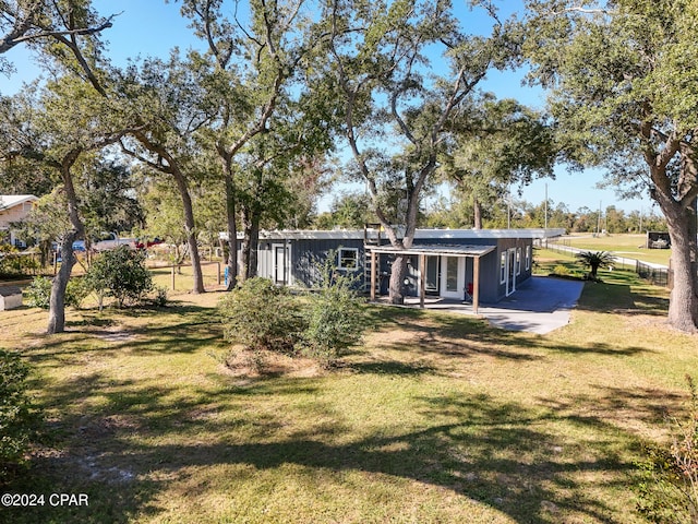 back of house featuring a lawn and a patio