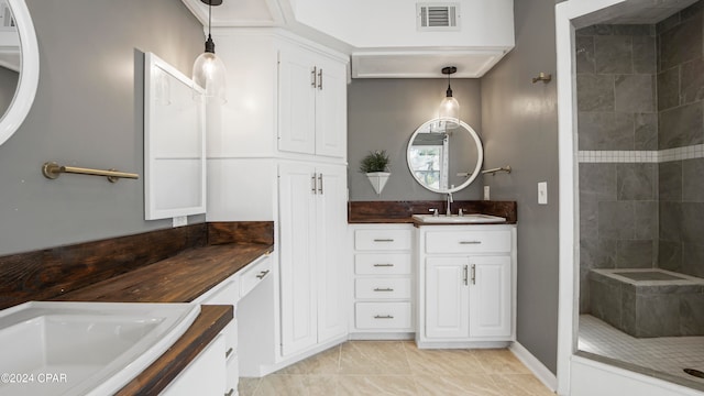 bathroom featuring tile patterned floors, vanity, and tiled shower