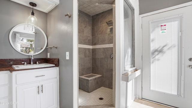 bathroom with tiled shower, vanity, tile patterned floors, and a healthy amount of sunlight