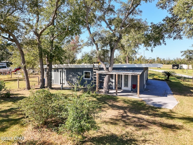 back of house featuring a lawn and a patio