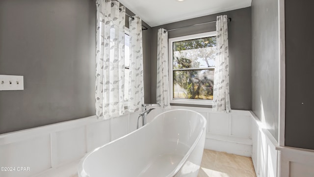 bathroom with tile patterned floors, a wealth of natural light, and a bathing tub