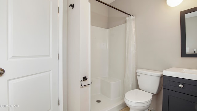 bathroom with curtained shower, vanity, and toilet