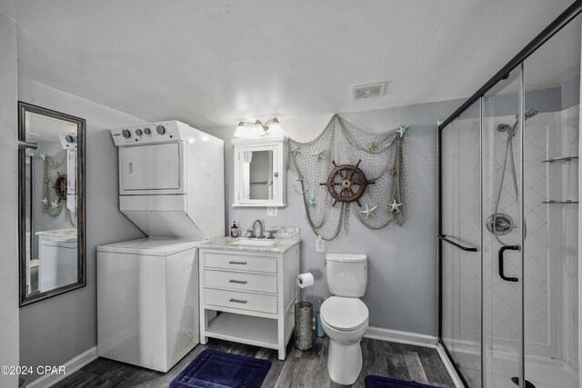 202 3rd St, Mexico Beach, FL 32456 - full bath with stacked washer / drying machine, toilet, vanity, baseboards, and wood finished floors
