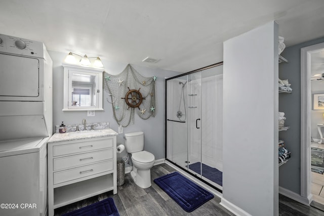 202 3rd St, Mexico Beach, FL 32456 - full bathroom with stacked washing machine and dryer, toilet, wood finished floors, a shower stall, and vanity
