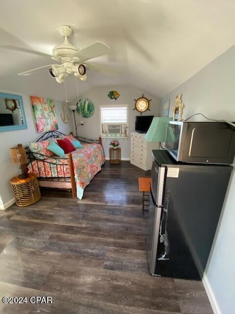 bedroom featuring lofted ceiling, ceiling fan, dark hardwood / wood-style floors, and stainless steel refrigerator