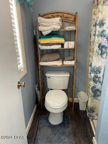 202 3rd St, Mexico Beach, FL 32456 - bathroom featuring toilet, wood finished floors, a shower with shower curtain, and baseboards