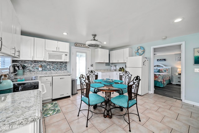 kitchen featuring white cabinetry, white appliances, and plenty of natural light