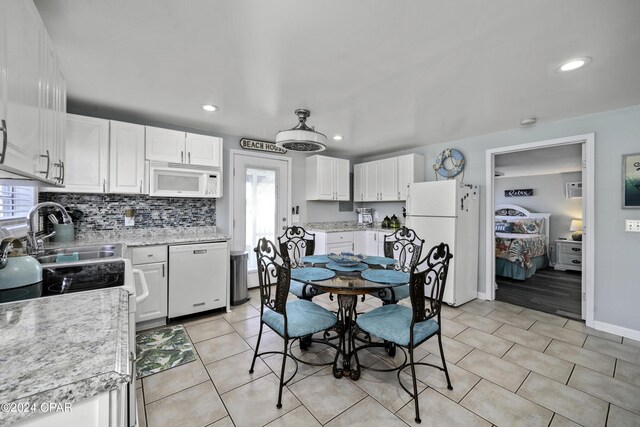 202 3rd St, Mexico Beach, FL 32456 - kitchen featuring white appliances, plenty of natural light, white cabinets, backsplash, and recessed lighting