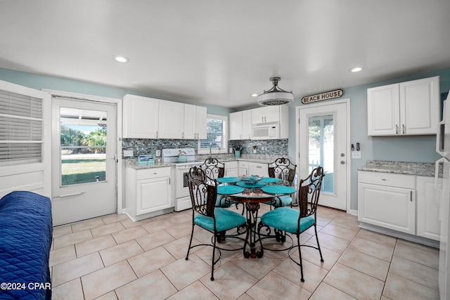 kitchen featuring white cabinetry, stove, and plenty of natural light