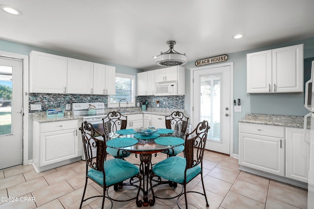 kitchen featuring white cabinets and range with electric cooktop