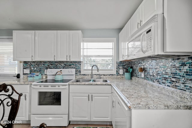 kitchen with white cabinets, tasteful backsplash, sink, and white appliances