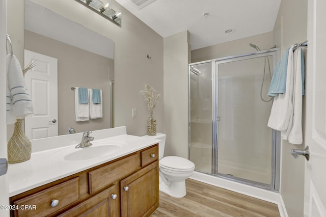 bathroom with vanity, an enclosed shower, toilet, and wood-type flooring