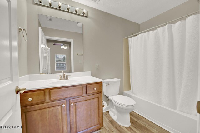 full bathroom with shower / bath combo, toilet, wood-type flooring, vanity, and a textured ceiling