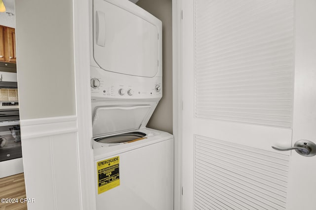 washroom with stacked washer / dryer and hardwood / wood-style flooring