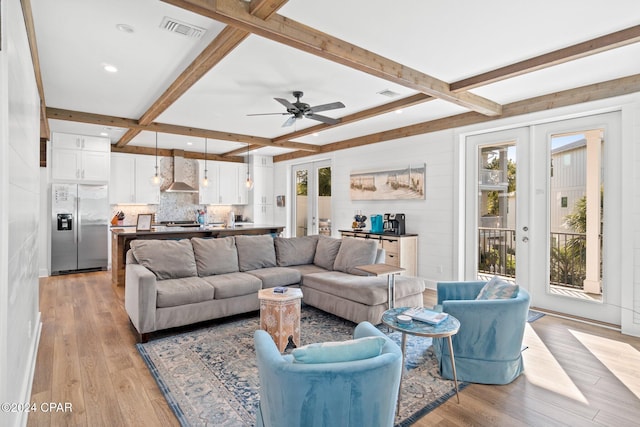 living room with beam ceiling, ceiling fan, french doors, and light hardwood / wood-style floors