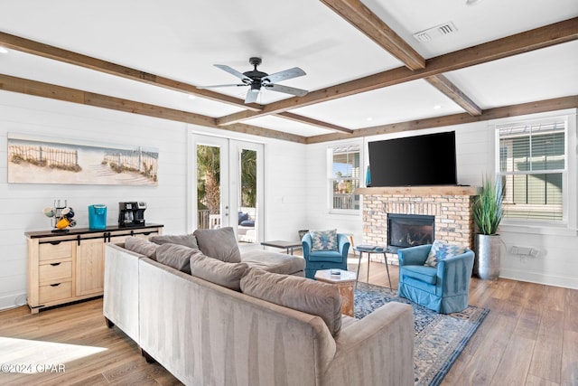 living room with hardwood / wood-style floors, wooden walls, a fireplace, and beamed ceiling