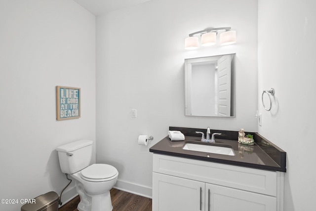 bathroom featuring toilet, vanity, and hardwood / wood-style flooring