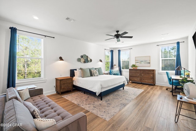 bedroom with ceiling fan, light wood-type flooring, and multiple windows