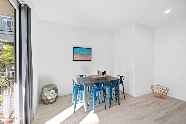 dining area with light hardwood / wood-style flooring and a healthy amount of sunlight