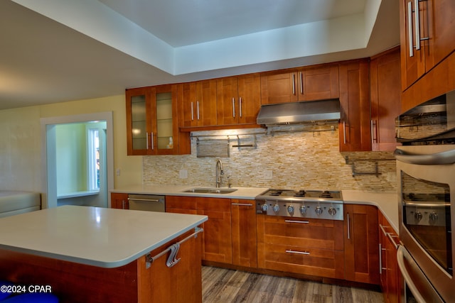 kitchen with decorative backsplash, a kitchen island, appliances with stainless steel finishes, dark wood-type flooring, and sink