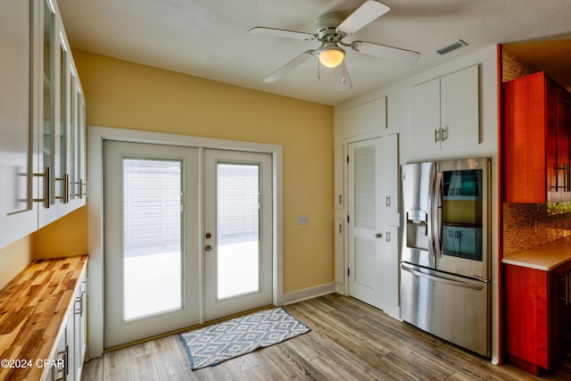 kitchen featuring french doors, butcher block countertops, stainless steel fridge, light hardwood / wood-style floors, and white cabinets