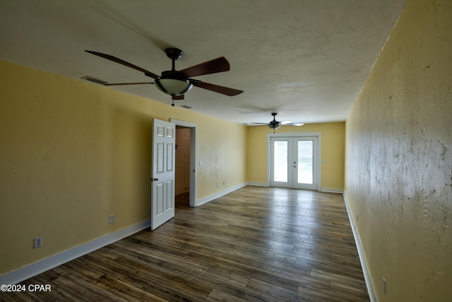 empty room featuring french doors, dark wood-type flooring, and ceiling fan