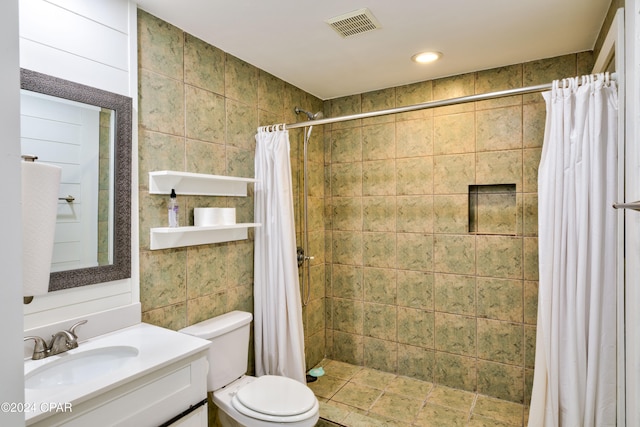 bathroom featuring toilet, walk in shower, vanity, and tile walls