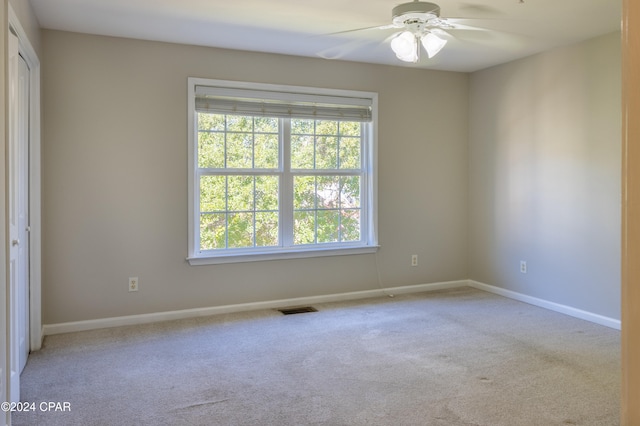 carpeted empty room featuring ceiling fan