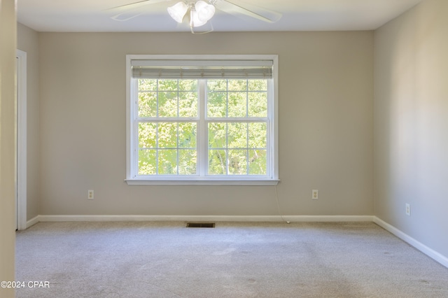 unfurnished room featuring light carpet, plenty of natural light, and ceiling fan