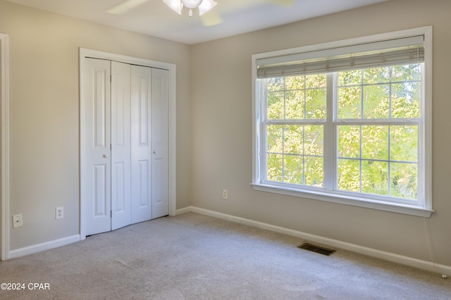 unfurnished bedroom with a closet, ceiling fan, and light colored carpet