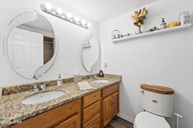 bathroom with toilet, vanity, and hardwood / wood-style floors