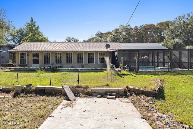 rear view of property with a fenced in pool, a yard, and glass enclosure