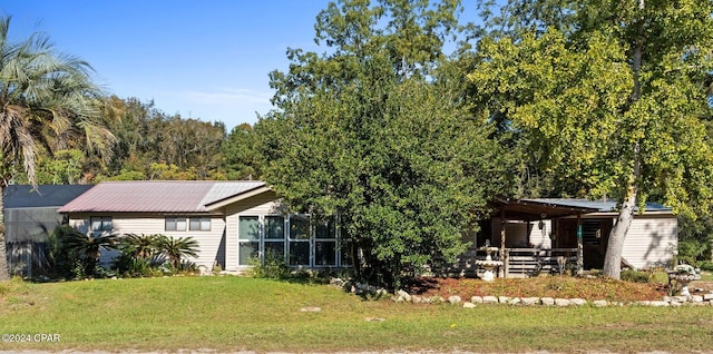 rear view of house featuring a yard