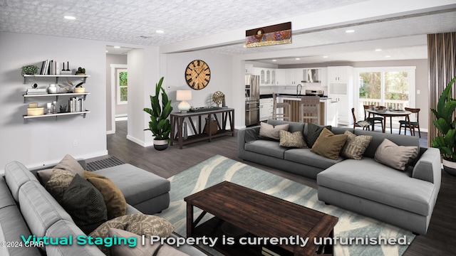 living room featuring sink, a textured ceiling, and dark hardwood / wood-style floors