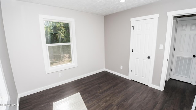 spare room featuring a textured ceiling, recessed lighting, baseboards, visible vents, and dark wood-style floors
